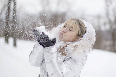 吹雪花的一件白色夹克的妇女图片