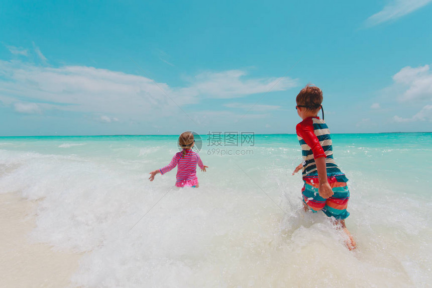 女孩和男孩在热带海滩图片