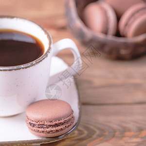 白杯黑咖啡和法国甜点木本底巧克背景图片
