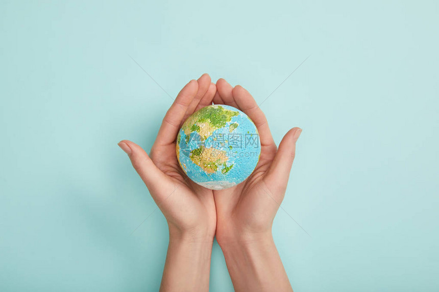 以绿松石背景地球日概念为模型的女拥有地球模图片