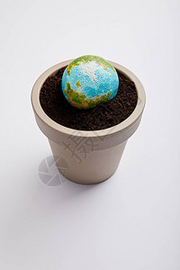 在花盆上放置的行星模型与土壤图片
