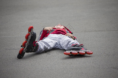 滑雪冰男孩躺在人行道上滑图片