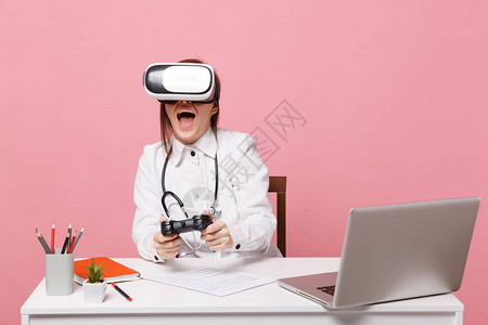 女医生坐在电脑前的办公桌前工作图片