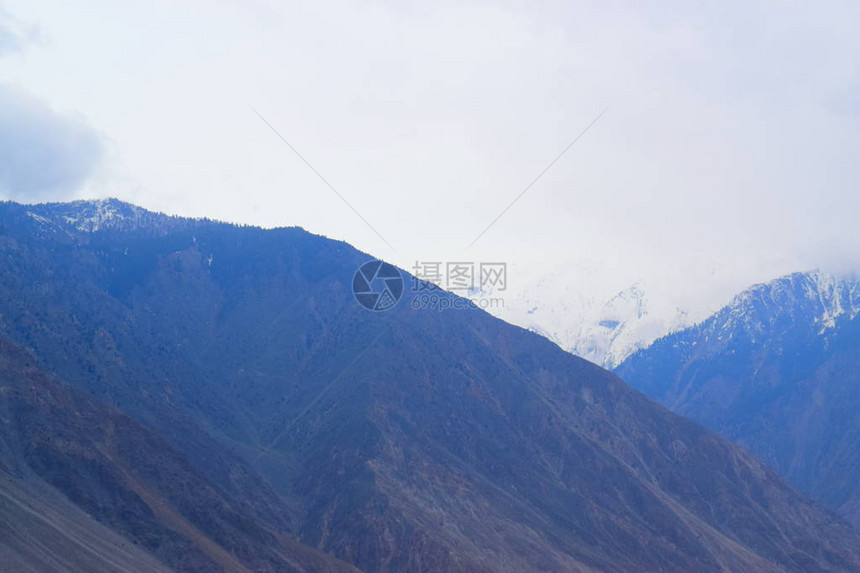 在山上看到山脚和雪山背景美丽的山脚地景色图片