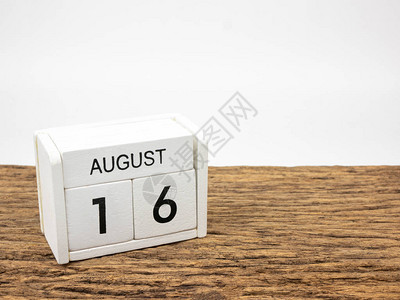 8月16日白方块木本日历在旧木和白色背景上与夏日图片