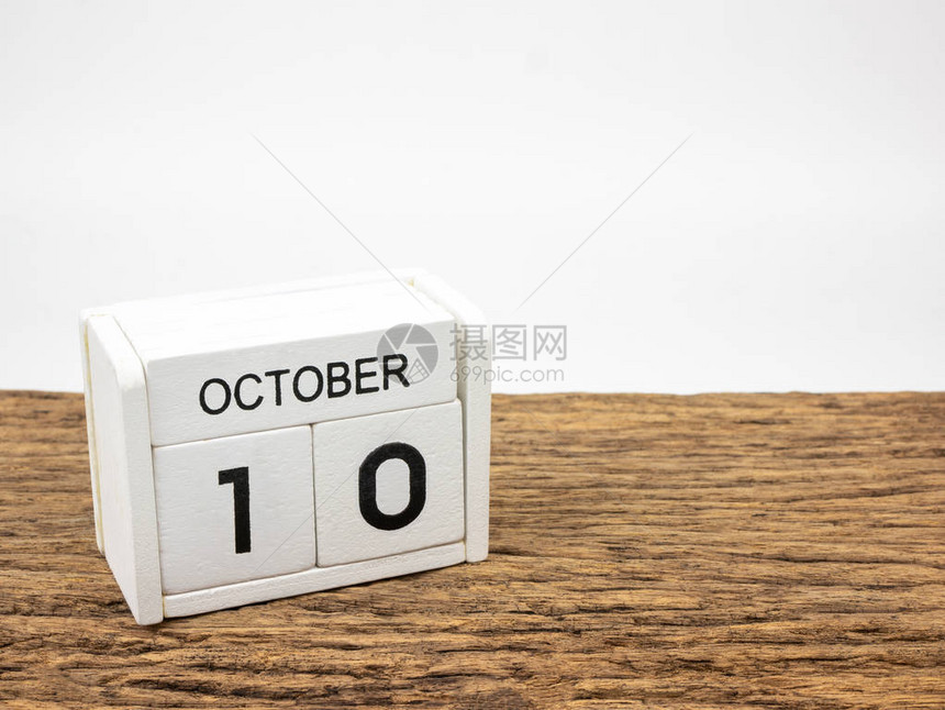 十月日白色立方木日历在旧木和白背景上与秋天图片
