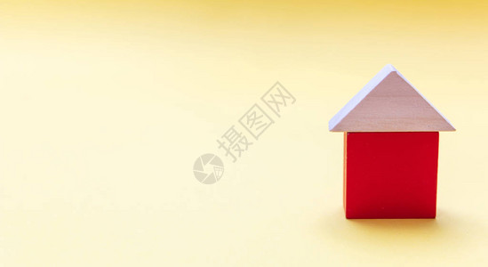 房地产有屋顶模型的红色小屋黄色背景木块图片