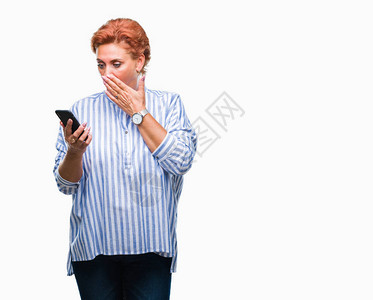 迷人的高加索红发女在孤立的背景上用智能手机发短信图片