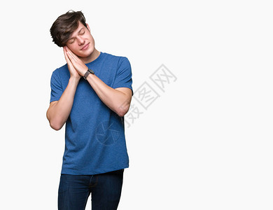 身穿蓝色T恤的英俊男青年在孤立的背景中沉睡于疲倦的梦里图片