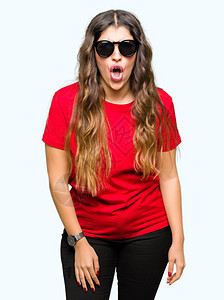 身穿红色T恤和太阳镜的年轻美女惊恐惊慌失措恐惧与兴奋的脸庞图片