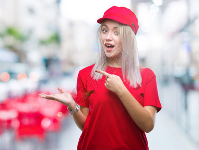 年轻的金发女郎在孤立的背景下戴着红色帽子图片