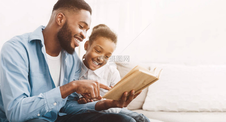 非裔美国人的爸和女儿一起在家阅读书图片