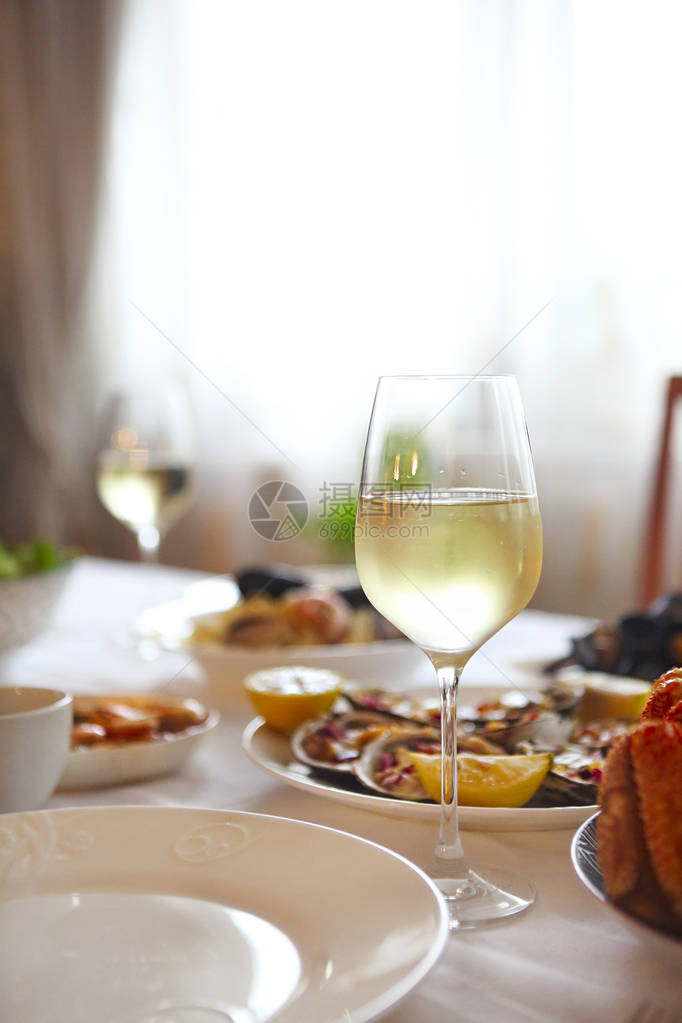 人们在餐桌上享用海鲜和白葡萄酒图片