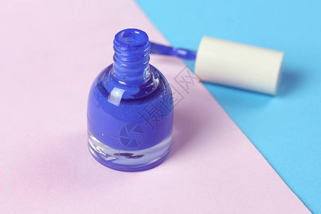 蓝指甲涂漆油瓶和粉红色背景的指甲刷子指图片