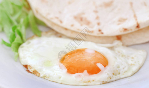 蛋和玉米饼面包在盘子里像图片