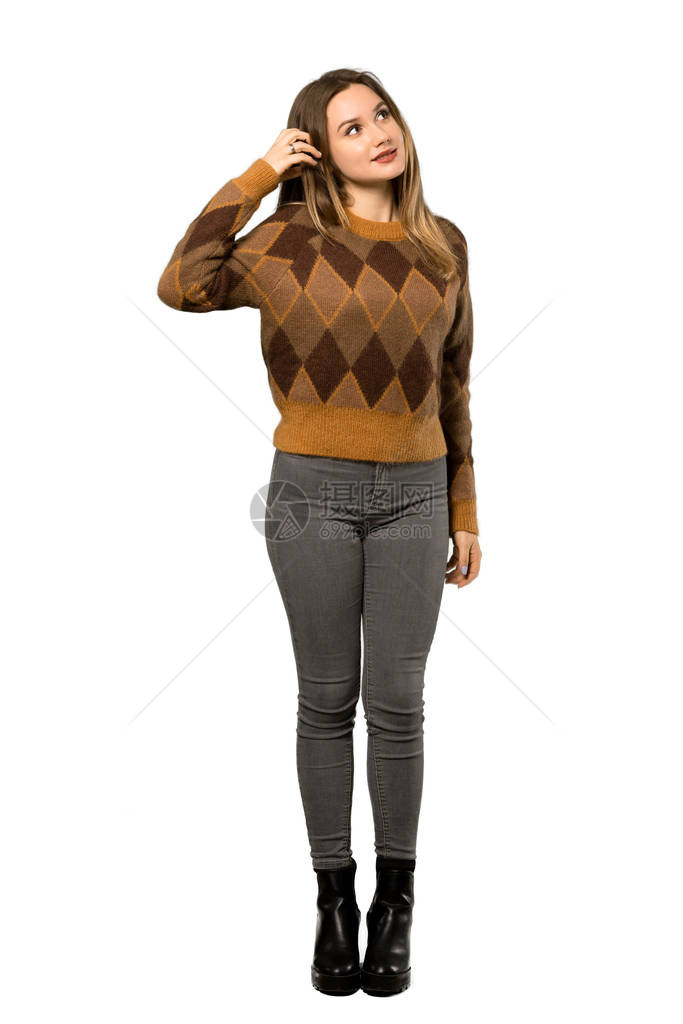 拍了一整张照片一个穿棕色毛衣的青少年女孩在孤立的白背景上抓头时图片