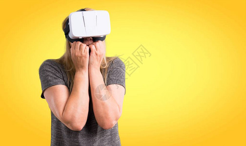 使用VR眼镜的中年金发女子关于丰富多彩背景的图片