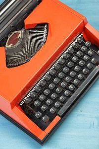 蓝色书桌或子上的红色打字机顶视图背景图片