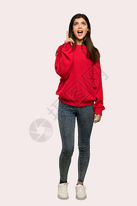 一个穿红色毛衣的青少年女孩被一整张照片拍到她想用孤立的背景图片