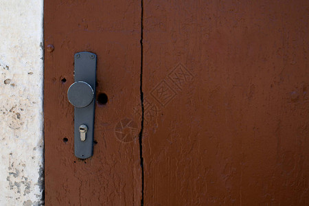 棕色谷仓门的彩绘门把手和钥匙孔空旷的空间图片