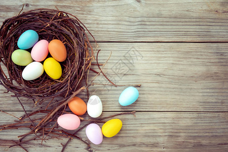 五颜六色的复活节彩蛋在仿古木板背景上的巢穴中春季假期复古色调风格图片