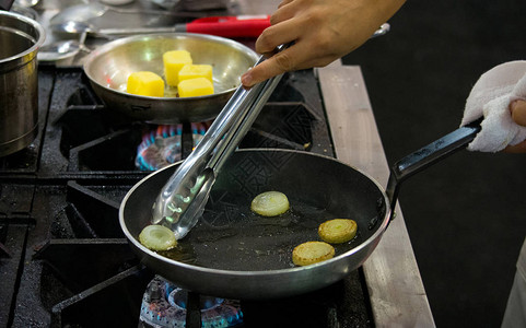 厨师在厨房做饭在锅里炒蔬菜图片