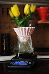 在粉红色陶瓷滴水器中用纸过滤器煮咖啡的替代咖啡电子比例背景黄图片