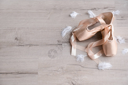 木地板上有羽毛的芭蕾舞鞋图片