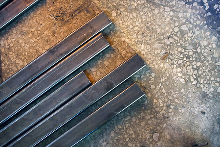 管道金属剖面图位于车间的混凝土地板上实施金属结构的工业背景复制版面空图片