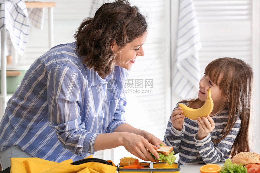 母亲和可爱女儿在家准备学图片