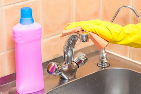 女人用抹布洗厨房的水龙头手戴黄图片