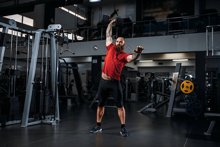 强壮的举重运动员用哑铃锻炼图片