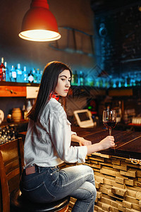 坐在木酒吧柜台的酒杯红酒女青年女士女顾图片