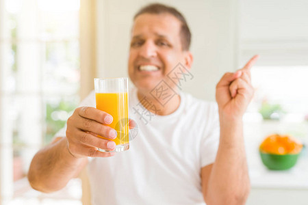 中年男子在家里喝杯橙汁图片