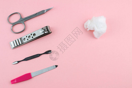 粉红色背景上的修指甲和修脚工具图片