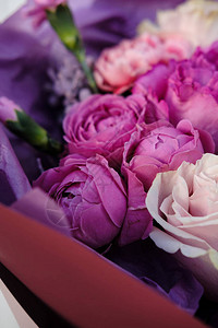 粉红色和紫色的玫瑰花束女人在花店准备花束特写图片
