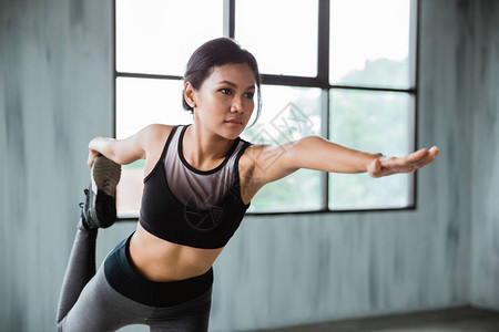伸展运动的女人在运动服室内锻炼图片