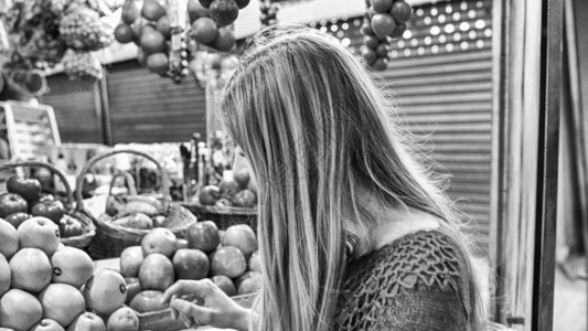 女人在市场上挑选水果背景图片