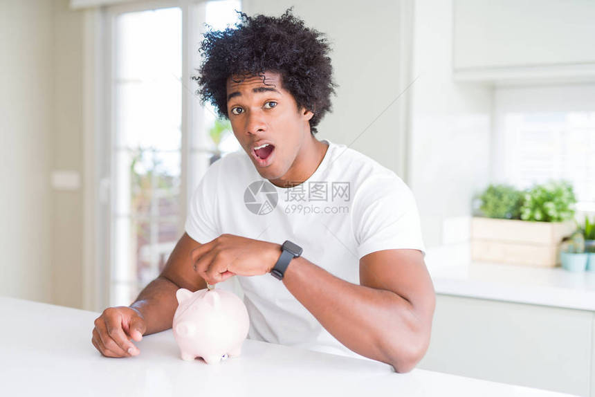 非裔美国人在小猪银行里放一枚硬币图片