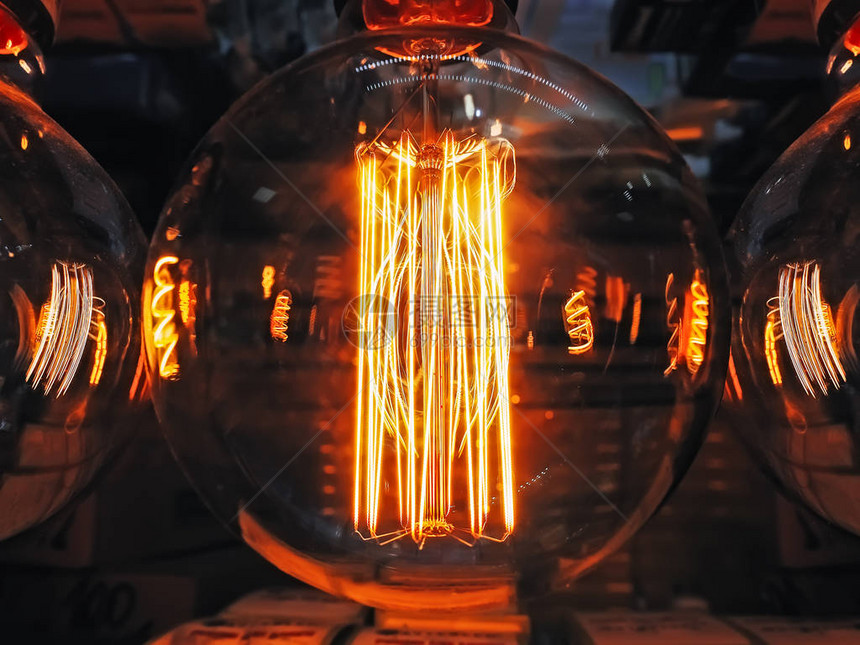 明亮发光的透明玻璃灯球形关闭照明爱迪生复古灯深色背景古董老式灯丝泡抽图片