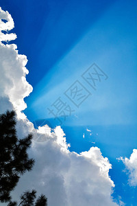 太阳光芒闪耀与云彩和蓝天背景图片