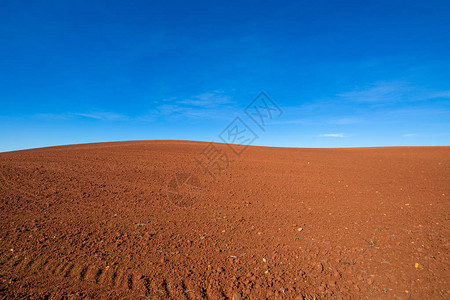 准备耕种和蓝天的耕地的棕土山轮廓曲线背景