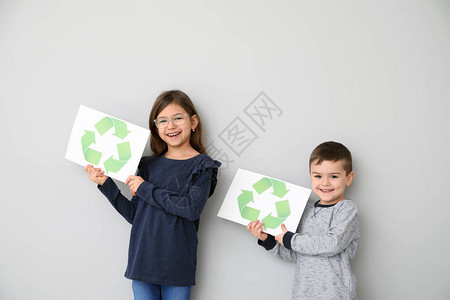 儿童在白背景上持有带回收符图片