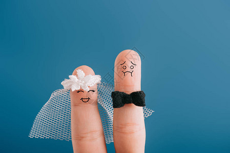 将手指作为快乐的新娘和神经紧张的新郎在图片