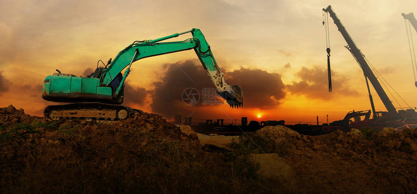 日落时在建筑工地作的挖掘机全景图片