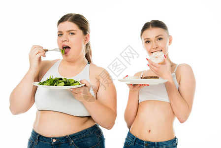 胖女人吃甜圈而超重女人吃绿色菠菜图片