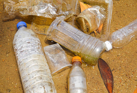 在湖中不当处置不可生物降解的聚氯乙烯杯和瓶子的不良恶习图片