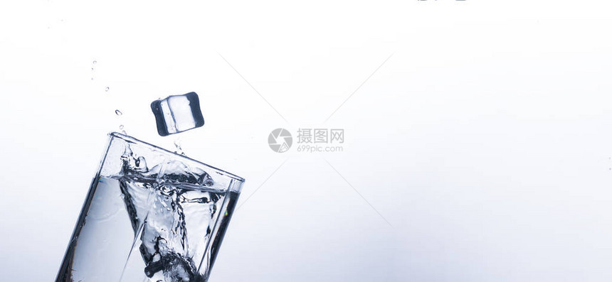 从白色背景上的冰块在玻璃杯中飞溅的水在炎热的天气里解渴和冷却饮料的概念水平衡和日常图片