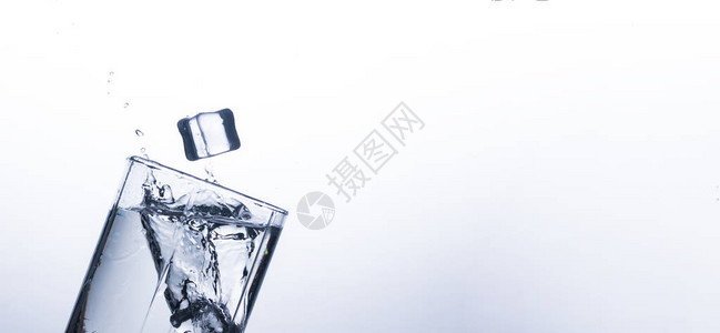 从白色背景上的冰块在玻璃杯中飞溅的水在炎热的天气里解渴和冷却饮料的概念水平衡和日常背景图片