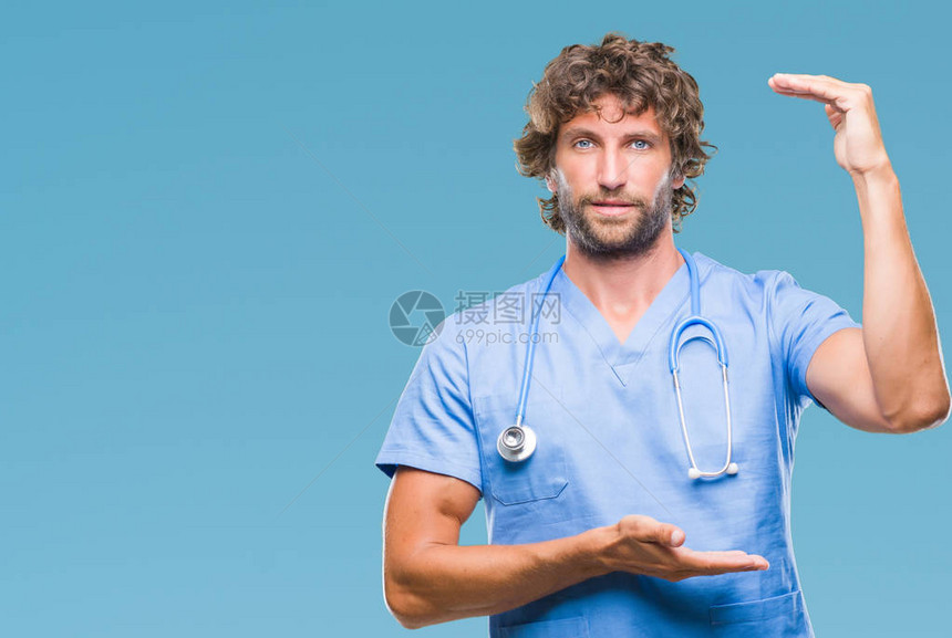 英俊的西班牙外科医生在孤立的背景下用双手展示大小的标志图片